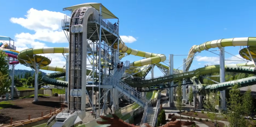 A water park featuring multiple colorful water slides and a tall slide tower under a clear blue sky.